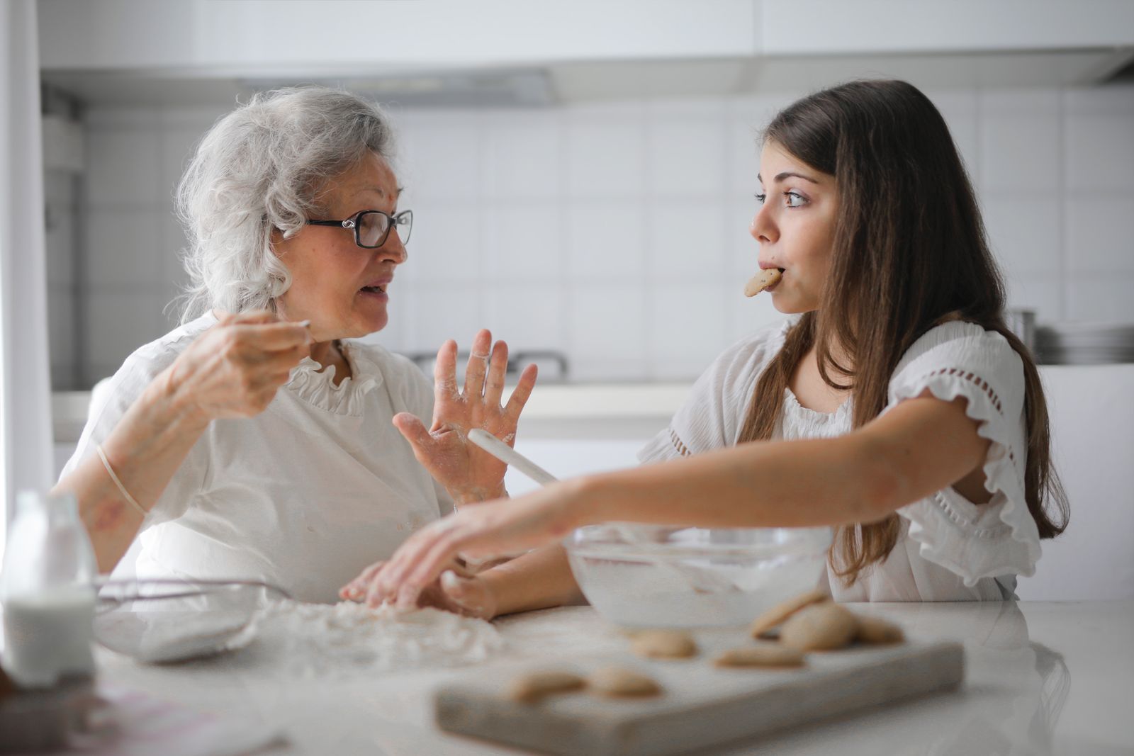 A grandmother and her granddaughter talking at the kitchen table