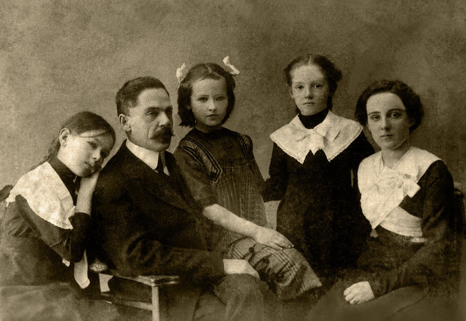 An old studio portrait of a family in sepia tones