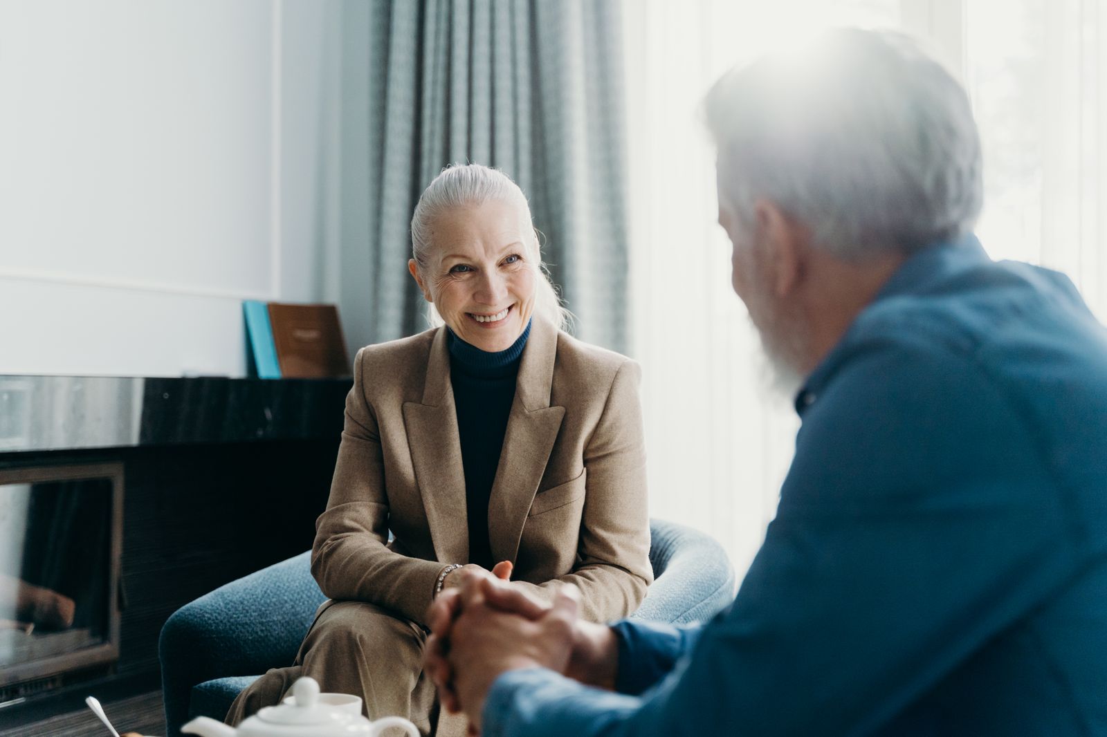 An older woman listening to a man tell a story in a living room